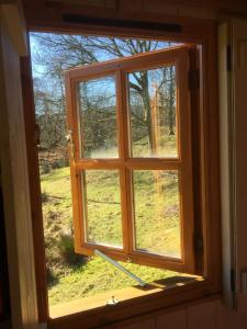 an open window with a view of a field at Ghyll Shepherd's Hut in Rydal