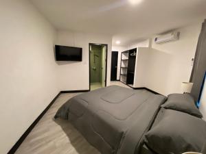 a bedroom with a bed and a flat screen tv at Chaweng Residence in Chaweng