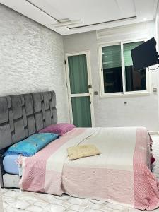 a bedroom with a bed and a flat screen tv at Refined Me Apartment Bb in Casablanca