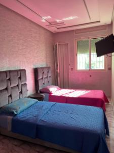 a bedroom with two beds and a tv in it at Refined Me Apartment Bb in Casablanca