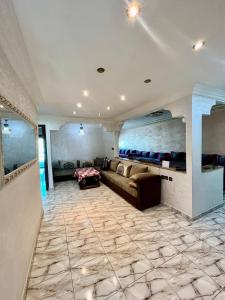uma ampla sala de estar com um sofá e piso em azulejo em Refined Me Apartment Bb em Casablanca