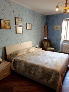 1 dormitorio con 1 cama en una habitación con paredes azules en Casa di Dario en Pettenasco