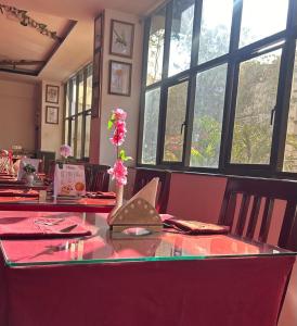 a dining room table with a vase with flowers on it at Twin Spring in Gangtok