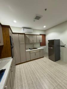 an empty kitchen with a black refrigerator in a room at ٣ غرف و صاله in Riyadh