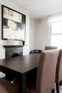 a dining room with a wooden table and chairs at Madison Hill - Fernlea View 4 - Two bedroom flat in London