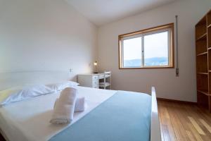 ein weißes Schlafzimmer mit einem Bett und einem Fenster in der Unterkunft Quinta da Armada, Apartamento em Braga by House and People in Braga