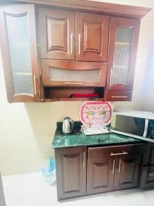 a kitchen with wooden cabinets and a counter top at Afnan Cairo Airport in Cairo
