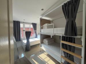 a small room with bunk beds and a window at BeHome and Hostel in Chiang Mai