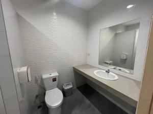 W łazience znajduje się toaleta, umywalka i lustro. w obiekcie BeHome and Hostel w mieście Chiang Mai