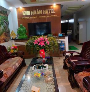 un soggiorno con divani e un tavolo con fiori di Kim Ngân Hotel Lào Cai a Lao Cai