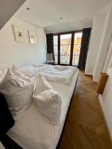 una camera da letto con due letti con lenzuola bianche di Luxus Suite mit einmaligem Blick auf die Frauenkirche a Dresda