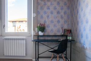 escritorio y silla en una habitación con ventana en Aretium, en Arezzo