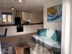uma sala de estar com um sofá e uma cozinha em New Luxury Modern Apartment em Milton Keynes