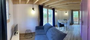 un soggiorno con divano blu e tavolo di Gite Le Jardin des 4m a Saint-Régis-du-Coin