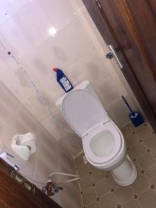 a bathroom with a toilet with a blue object on it at Jambo hostel tz in Dar es Salaam