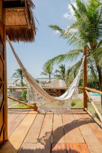 a hammock on the deck of a resort with palm trees at Villa Mango in Icaraí