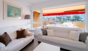 a living room with two white couches and a window at Apartamento Dos Mares by Rental Olé in La Manga del Mar Menor