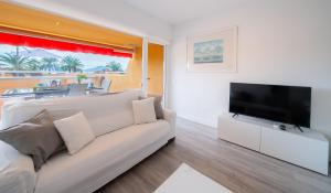 a living room with a couch and a flat screen tv at Apartamento Dos Mares by Rental Olé in La Manga del Mar Menor