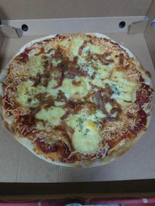 une pizza assise dans une boîte à pizza dans l'établissement ibaia le bonheur, à Frontignan