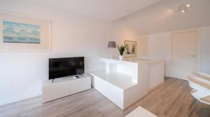 a white living room with a flat screen tv at Apartamento Dos Mares by Rental Olé in La Manga del Mar Menor