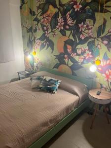 1 dormitorio con 1 cama con una pintura en la pared en 'Na Pace dei Santi B&B, en Porto SantʼElpidio