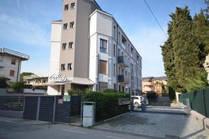un edificio blanco alto con una valla delante en la Bohème Peschiera luxury apartment, en Peschiera del Garda