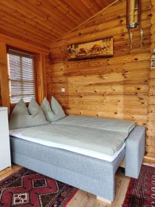 a bed in a room with a wooden wall at Harrys Blockhütte in Karres
