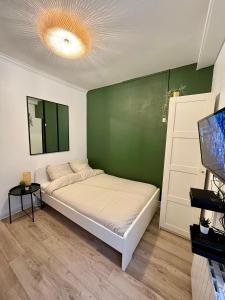 Ce lit se trouve dans un dortoir doté d'un mur vert. dans l'établissement Au ColbVert, à Lille