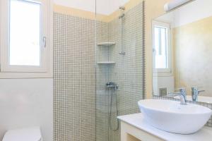 a bathroom with a sink and a shower at Villa Olive Grove Kefalonia in Ferendináta +10 photos