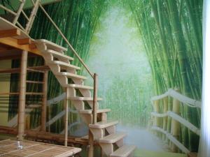 a bamboo wall mural in a room with a spiral staircase at ARTHARMONY Pension & Hostel in Prague