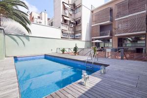 una piscina frente a un edificio en Barcino Inversions - Bright Apartment in Gracia with shared Pool en Barcelona