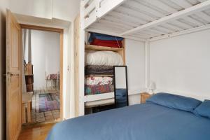 a bedroom with a blue bed and a closet at Appartement au coeur du Marais à Paris by Weekome in Paris