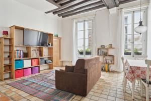 a living room with a couch and a tv at Appartement au coeur du Marais à Paris by Weekome in Paris