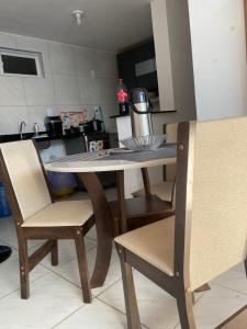 a table and chairs in a kitchen with a table and a kitchen at Apartamento em João Pessoa in João Pessoa