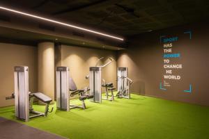 a gym with several treadmills and a sign on the wall at Hotel SB Win in Sant Feliu de Llobregat