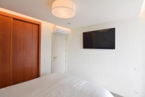 a bedroom with a bed and a flat screen tv at Cisne 32 in Playa del Ingles