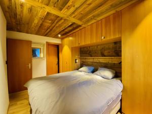 Fontanettaz V 007 - MOUNTAIN & VIEW apartment 8 pers في فييسوناز: غرفة نوم بسرير كبير وبجدار خشبي