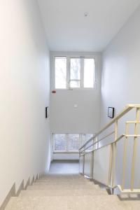 a staircase with a window in a white building at Zefiro Na Gnilnej in Gdańsk