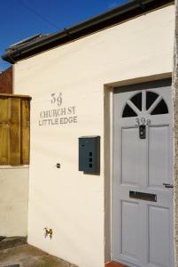 a white building with a door in front at Little Edge: Bright and Modern Central Apartment in Berwick-Upon-Tweed