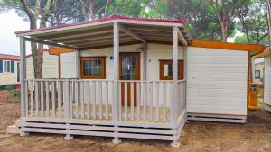 un petit hangar blanc avec un toit rouge dans l'établissement Camping Village Cavallino, à Cavallino-Treporti