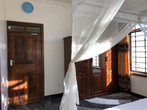 a bedroom with a bed with a mosquito net at Jambo hostel tz in Dar es Salaam