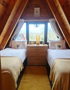 Snowdonia View@puffin Lodges في Chwilog: سريرين في غرفة مع نافذة
