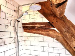 y baño con ducha y techo de madera. en Guest Homes - Gwenelin Cottage, en Bretforton