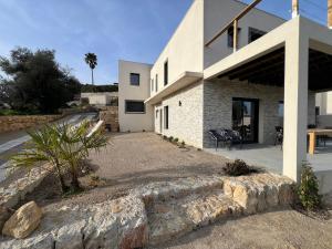 a house with a stone wall next to a driveway at Villa Nomade proche de Cannes in Vallauris