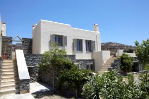 una casa blanca con escaleras delante en Diles & Rinies, en Tinos