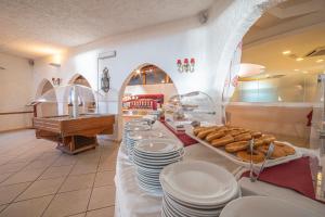 a bakery with a line of plates and pastries at Centro Vacanze Isuledda in Cannigione
