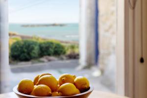 a bowl of oranges sitting on a table next to a window at Bijou Bolthole in Mousehole