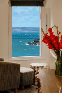 a room with a window with a view of the ocean at Bijou Bolthole in Mousehole