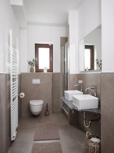 La salle de bains est pourvue de toilettes, d'un lavabo et de miroirs. dans l'établissement Haus Moorhoff, à Hanovre