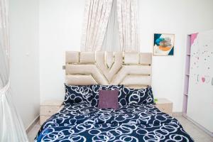 um quarto com uma cama com uma grande cabeceira de cama em The Serenity Villa em Lekki